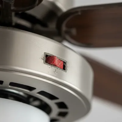 Close-up of a ceiling fan's direction switch, emphasizing a stuck or faulty appearance